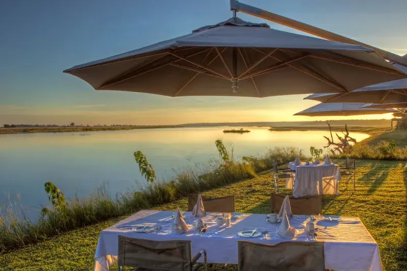 Dinner laid out beside the Chobe River at sunset at Chobe Game Lodge
