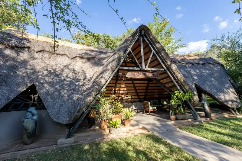 The thatched main lodge building at Masuwe Lodge surrounded by bush