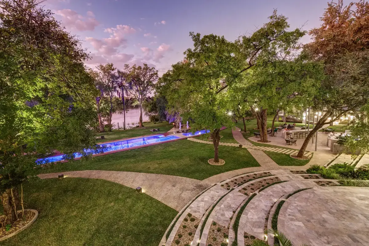 Hotel grounds and pool leading to the Zambezi River at The Palm River Hotel