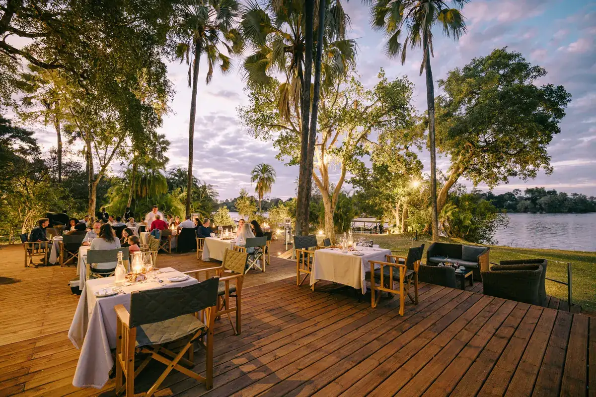 Riverside deck dining at dusk at The Palm River Hotel